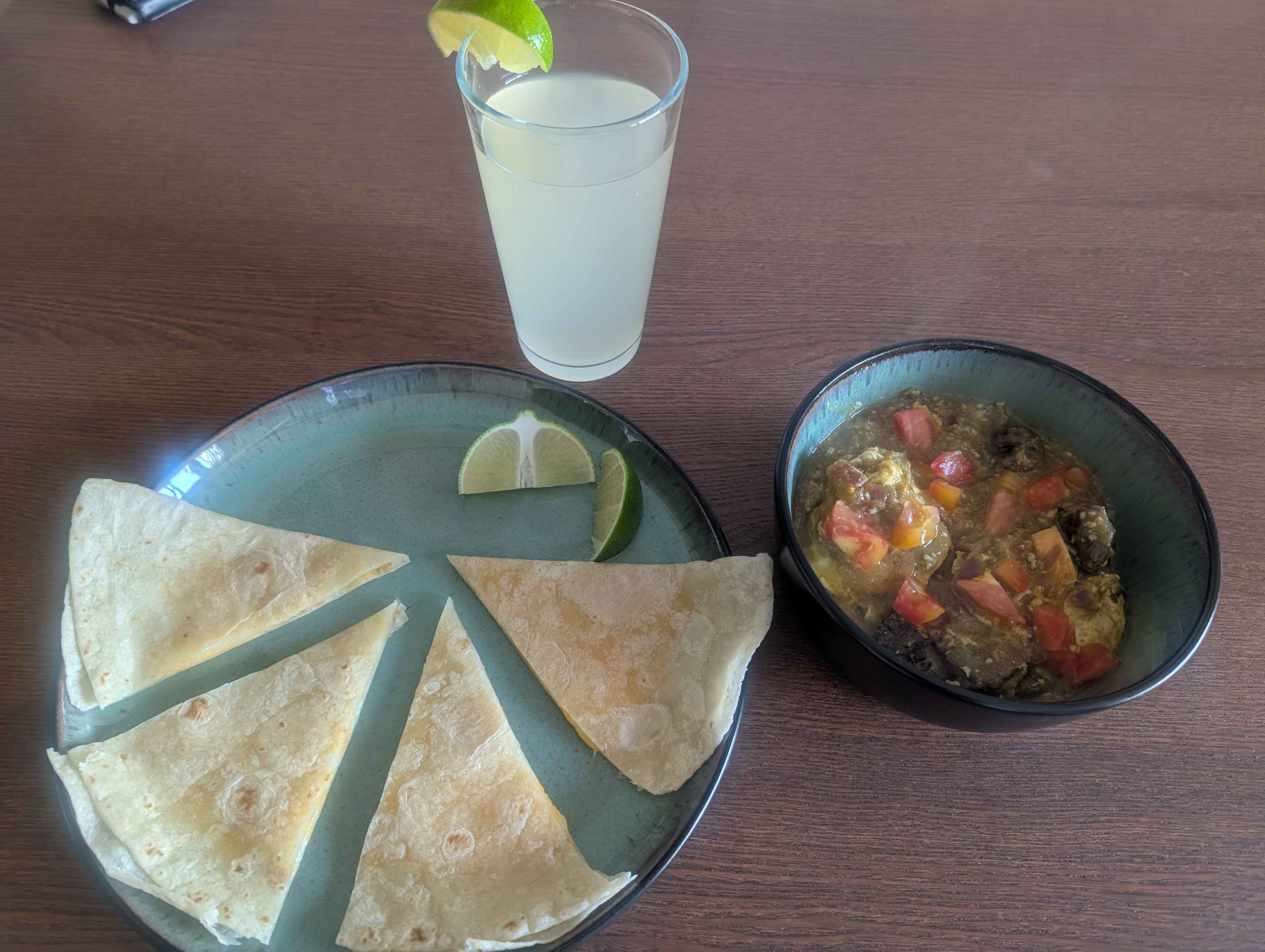Eggs poached in green enchilada sauce with cubes of ribeye, topped with diced tomato and lime.